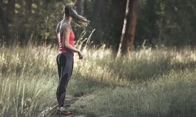 Frau in Sportkleidung steht im Wald. Tolle Jogging-Tipps für Anfänger und Fortgeschrittene.