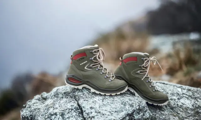 Grüne Lowa Renegade Wanderschuhe auf Felsen, bereit für den Test im Gelände.