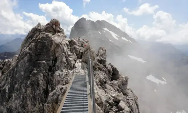 Ein steiler Metallsteg führt über felsige Gipfel. Ein Abenteuer auf dem Heilbronner Weg wandern.