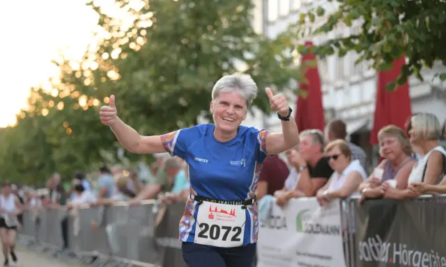 Läuferin mit Startnummer 2072 gibt beim Sparkassenlauf Aurich Daumen hoch.