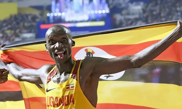 Läufer mit ugandischer Flagge, jubelt nach einem 5km-Weltrekord.