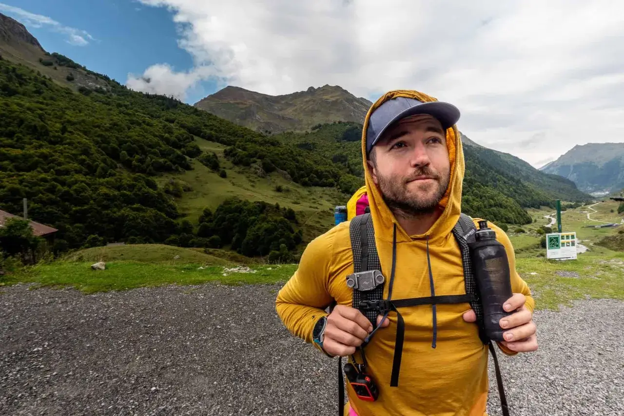 Mann mit Rucksack und Trinkflasche im Gebirge, bereit f&uuml;r Speed Hiking.