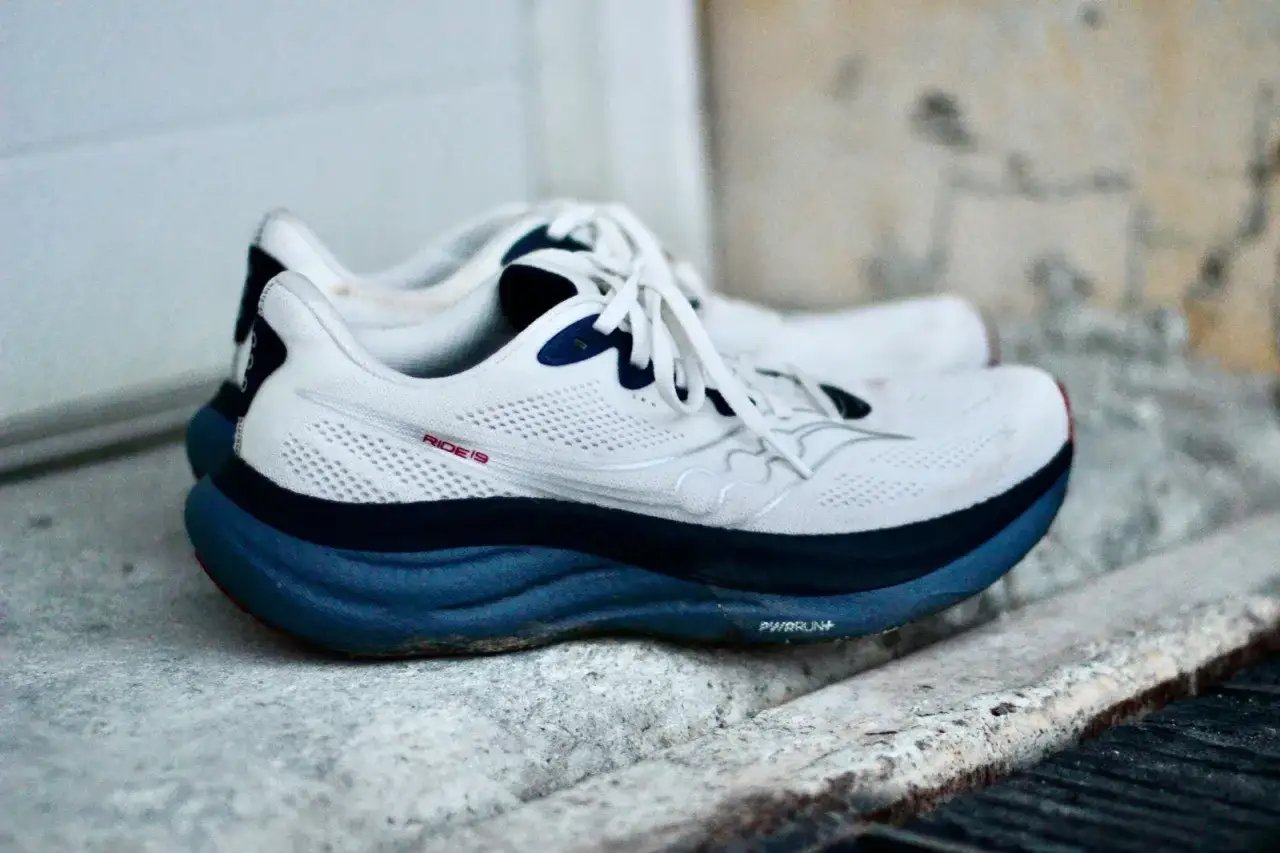 Wei&szlig;e Laufschuhe, Saucony Ride 19, mit blauer Sohle und Schn&uuml;rsenkeln, bereit f&uuml;r die n&auml;chste Laufrunde.