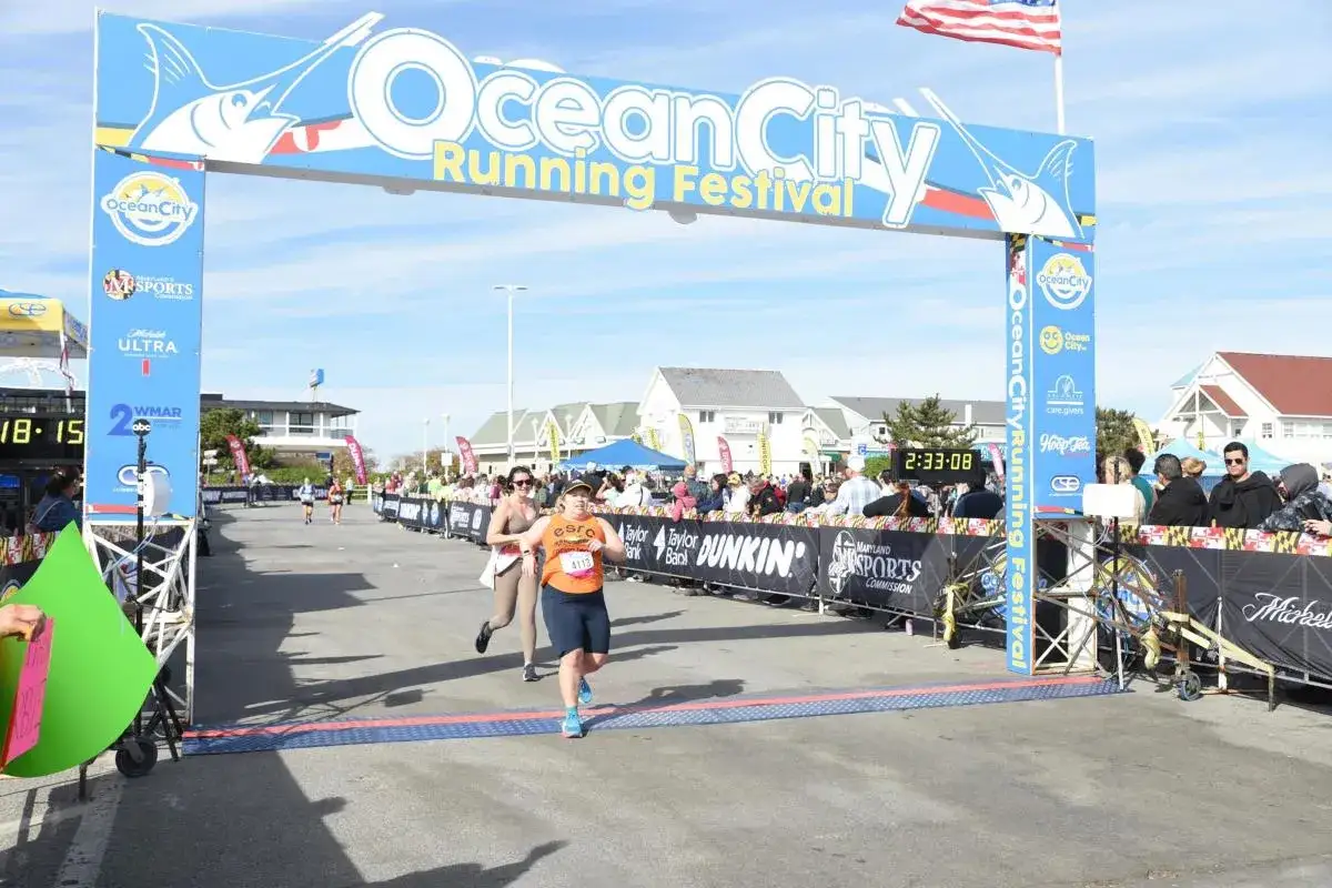 Läuferinnen überqueren die Ziellinie beim Ocean City Running Festival. Die halbmarathon distanz ist geschafft!