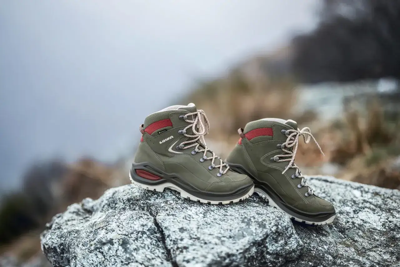 Grüne Lowa Renegade Wanderschuhe auf Felsen, bereit für den Test in den Bergen.