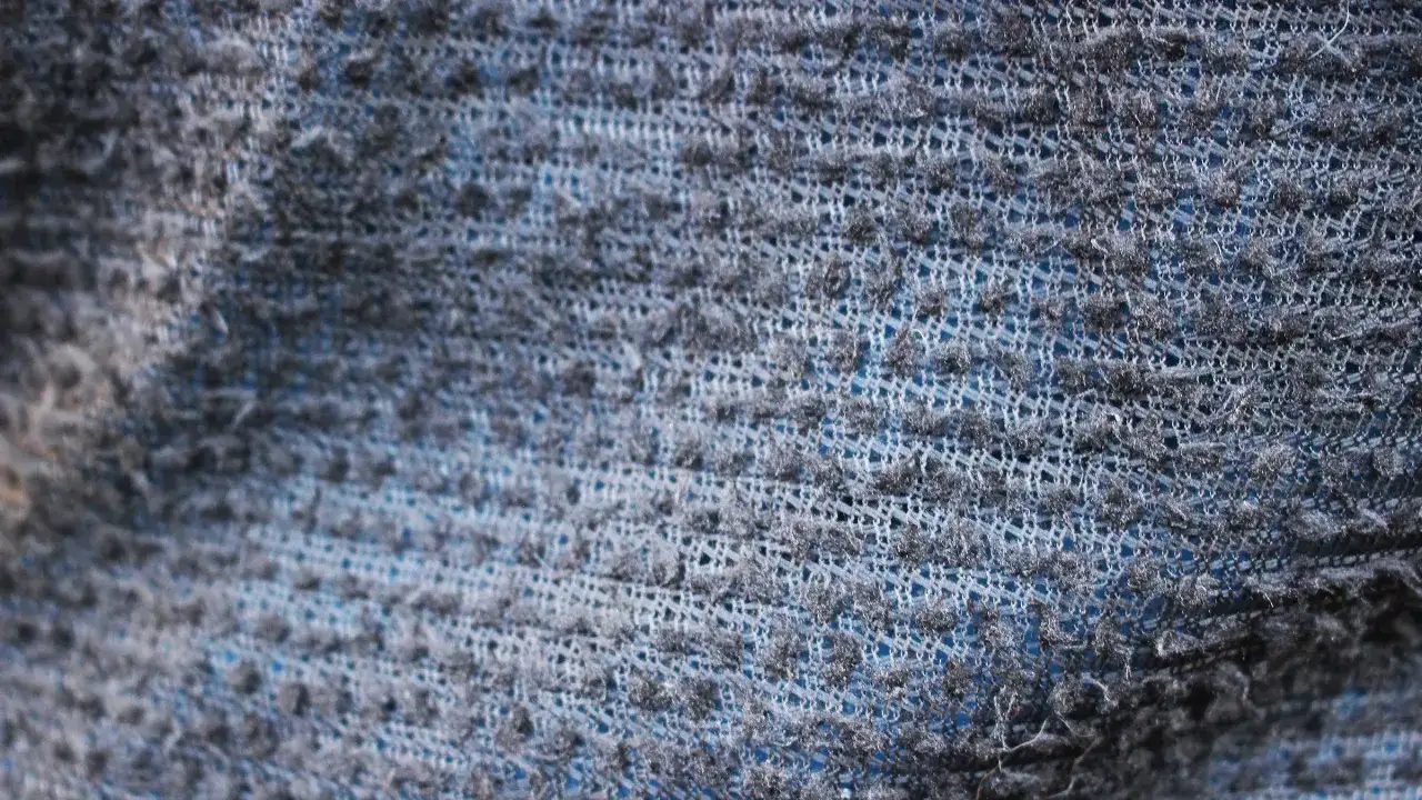 Struktur eines blauen Stoffes mit feiner Pertex Quantum Webung, die für Leichtigkeit und Strapazierfähigkeit sorgt.