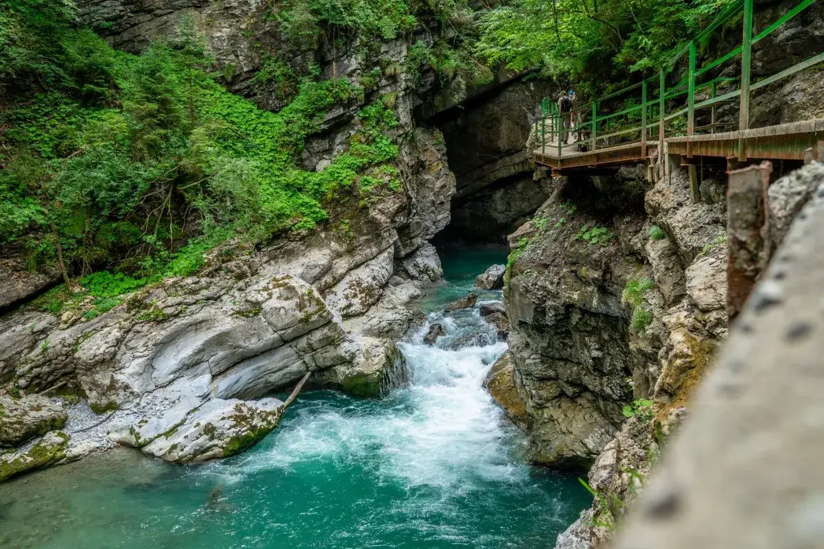 Ein leichter Wanderweg in Oberstdorf f&uuml;hrt entlang einer t&uuml;rkisfarbenen Klamm mit rauschendem Wasser und steilen Felsw&auml;nden.