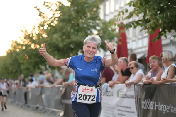 Läuferin mit Startnummer 2072 gibt beim Sparkassenlauf Aurich Daumen hoch.