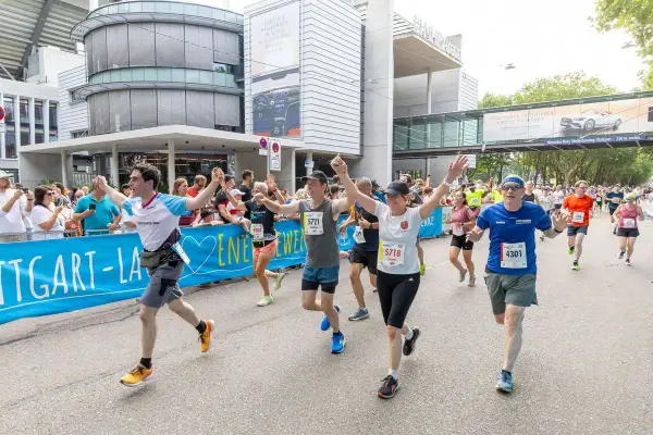 Läufer jubeln beim Marathon Stuttgart, überqueren die Ziellinie.