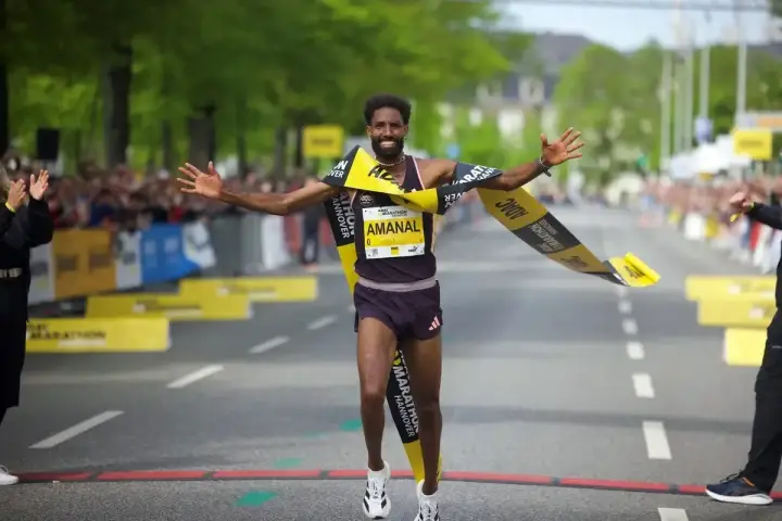 Läufer durchbricht jubelnd die Ziellinie beim Hannover Marathon. Ein Highlight im laufkalender niedersachsen.
